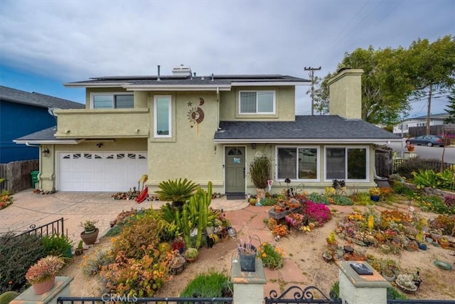 1585 Saratoga Ave, Grover Beach, CA 93433 - view of front of home featuring fence, an attached garage, a chimney, and solar panels