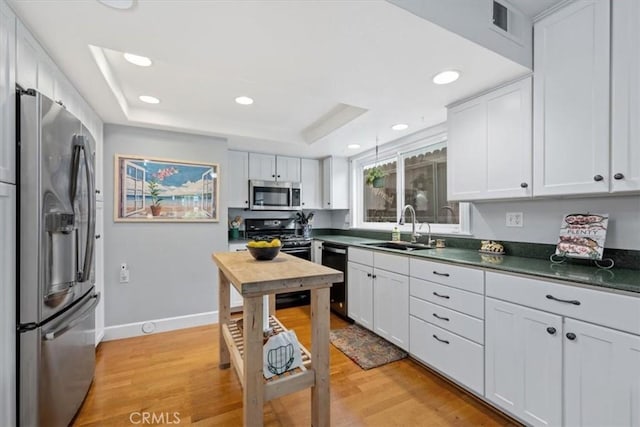 1585 Saratoga Ave, Grover Beach, CA 93433 - kitchen with black appliances, a sink, a tray ceiling, dark countertops, and white cabinets