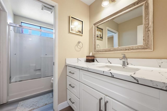 full bathroom featuring vanity, bath / shower combo with glass door, toilet, and wood finished floors