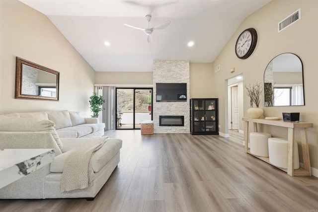 living room with a ceiling fan, high vaulted ceiling, visible vents, and wood finished floors