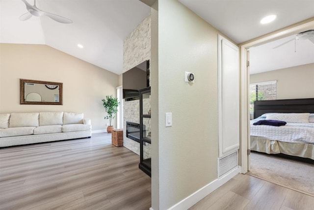 corridor featuring baseboards, vaulted ceiling, and wood finished floors