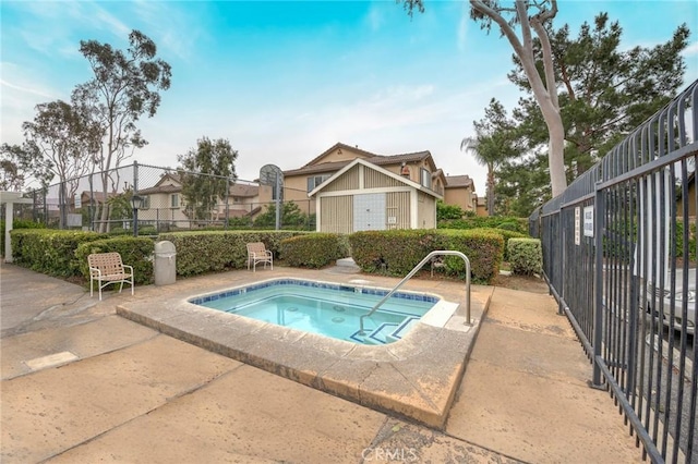 view of pool featuring a community hot tub and fence