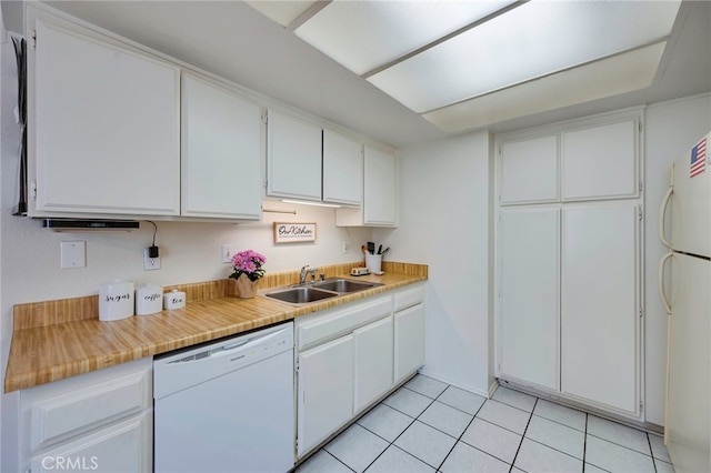 kitchen featuring light tile patterned flooring, white appliances, light countertops, white cabinets, and a sink