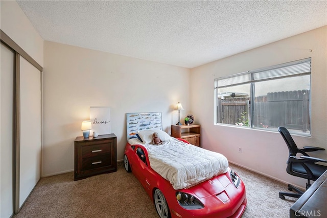 carpeted bedroom featuring a textured ceiling and a closet
