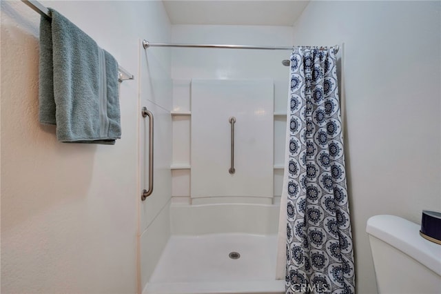 full bathroom with a shower with shower curtain and toilet