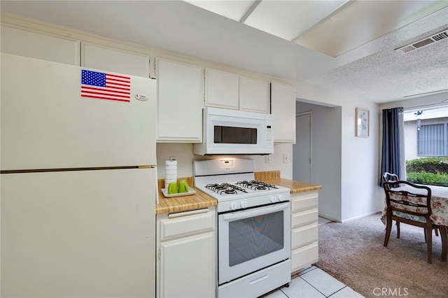kitchen featuring visible vents, light carpet, white appliances, light countertops, and white cabinetry