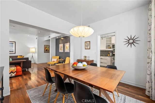dining space featuring baseboards and wood-type flooring