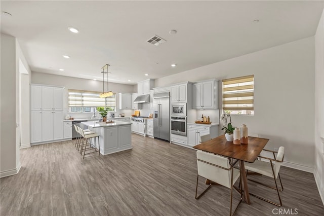 1776 Canyon Oaks Ln, Lake Forest, CA 92610 - kitchen featuring built in appliances, under cabinet range hood, light countertops, a breakfast bar, and white cabinets