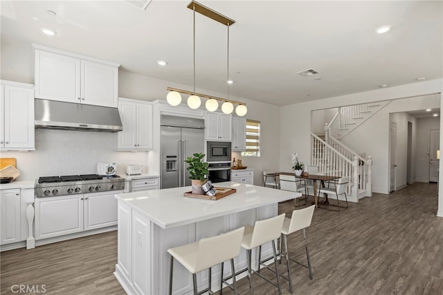 1776 Canyon Oaks Ln, Lake Forest, CA 92610 - kitchen with under cabinet range hood, built in appliances, a kitchen island, white cabinets, and recessed lighting