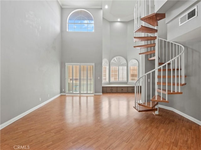 4301 Fulton Ave Unit 303, Sherman Oaks, CA 91423 - unfurnished living room with a towering ceiling, wood finished floors, baseboards, and stairs