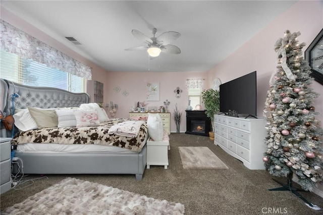 bedroom featuring multiple windows, carpet, ceiling fan, and visible vents