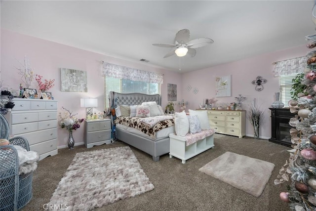 carpeted bedroom with baseboards, multiple windows, a ceiling fan, and visible vents