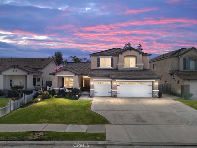 traditional-style house with a tiled roof, driveway, fence, an attached garage, and stucco siding