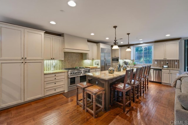 kitchen with built in appliances, backsplash, custom range hood, and dark wood-style flooring