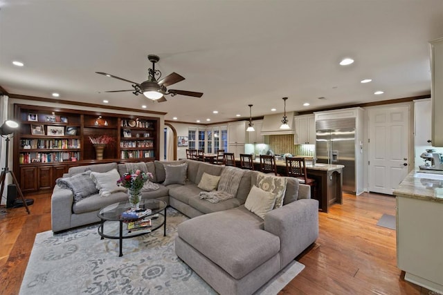 living room featuring crown molding, recessed lighting, ceiling fan, and light wood-style flooring