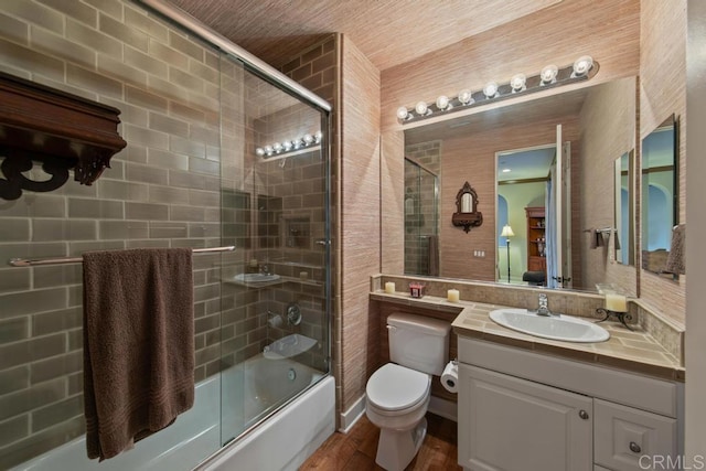 bathroom with shower / bath combination with glass door, vanity, toilet, and wood finished floors