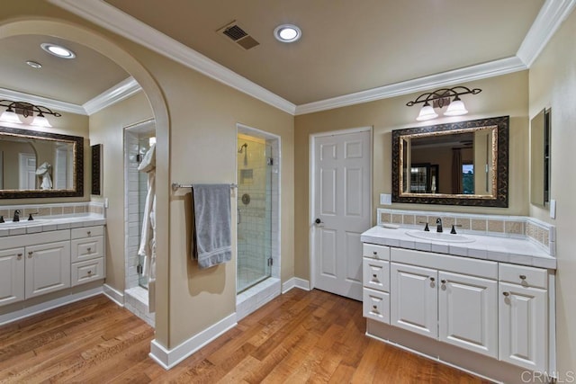 full bathroom featuring crown molding, visible vents, a sink, and a stall shower