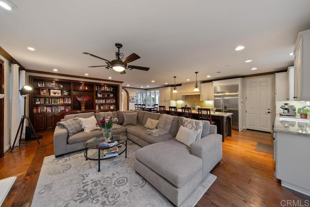 living room with hardwood / wood-style flooring, a ceiling fan, and recessed lighting