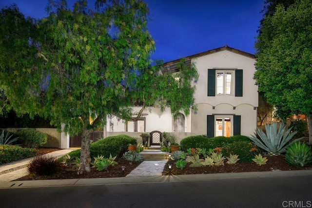 mediterranean / spanish-style house featuring stucco siding and fence