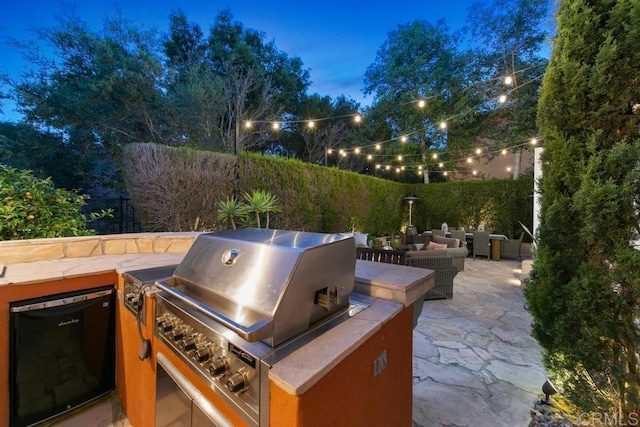view of patio / terrace featuring exterior kitchen, an outdoor living space, a fenced backyard, and a grill