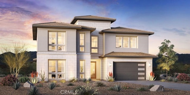 view of front of house featuring concrete driveway, an attached garage, and stucco siding