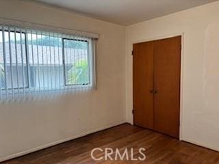 unfurnished bedroom featuring wood finished floors and a closet