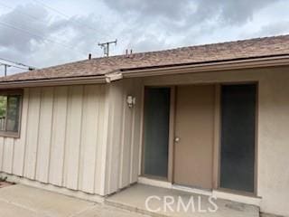 view of exterior entry with board and batten siding and stucco siding