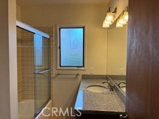 full bath with vanity and bath / shower combo with glass door