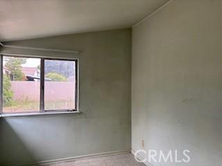 empty room with baseboards and lofted ceiling