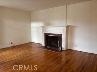 unfurnished living room featuring a fireplace and wood finished floors