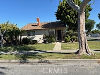 view of front of home with a chimney and a front yard