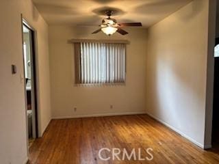 unfurnished room featuring baseboards, ceiling fan, and wood finished floors
