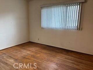 unfurnished room featuring baseboards and wood finished floors