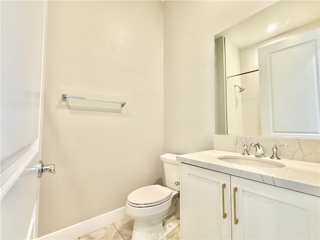 bathroom with tile patterned flooring, walk in shower, vanity, baseboards, and toilet