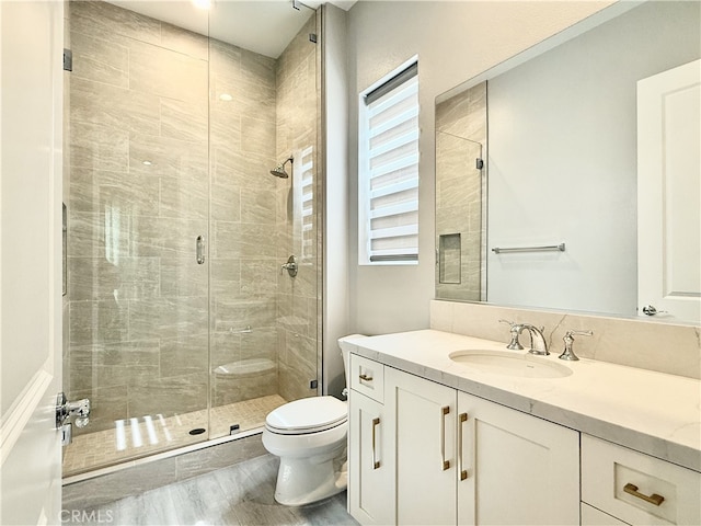 full bath featuring vanity, a stall shower, and toilet