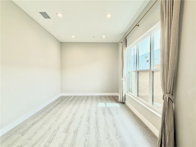 unfurnished room with recessed lighting, baseboards, visible vents, and light wood finished floors