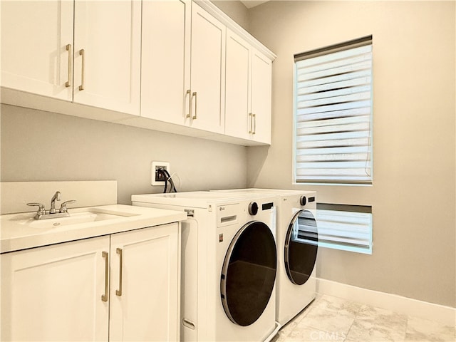 laundry room with cabinet space, washing machine and clothes dryer, a sink, marble finish floor, and baseboards