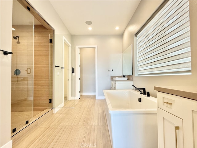 bathroom with vanity, recessed lighting, a freestanding bath, tile patterned floors, and a stall shower