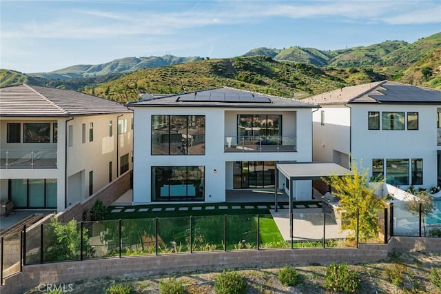20526 W Overlook Ct, Porter Ranch, CA 91326 - rear view of house featuring a fenced backyard, stucco siding, solar panels, a mountain view, and a patio area