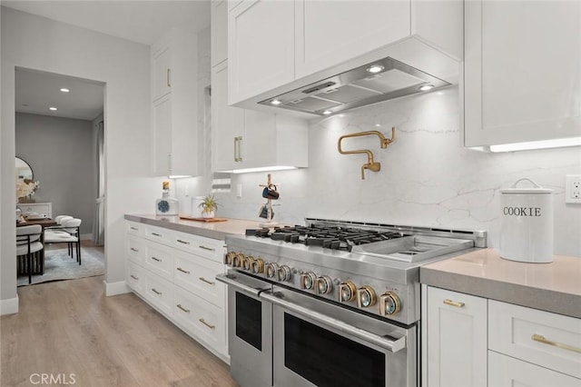 20526 W Overlook Ct, Porter Ranch, CA 91326 - kitchen featuring range with two ovens, custom exhaust hood, white cabinetry, decorative backsplash, and light wood-style floors