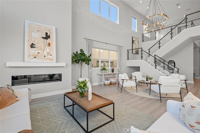 20526 W Overlook Ct, Porter Ranch, CA 91326 - living area with a high ceiling, wood finished floors, a chandelier, stairs, and baseboards