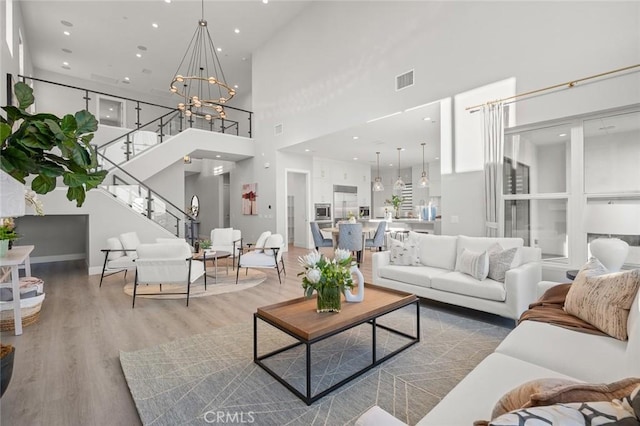20526 W Overlook Ct, Porter Ranch, CA 91326 - living area with a towering ceiling, stairs, wood finished floors, a chandelier, and recessed lighting