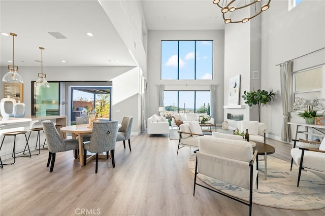 20526 W Overlook Ct, Porter Ranch, CA 91326 - dining area with a high ceiling, light wood-type flooring, a chandelier, a glass covered fireplace, and recessed lighting