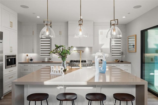 20526 W Overlook Ct, Porter Ranch, CA 91326 - kitchen featuring stainless steel oven, light wood-type flooring, a kitchen breakfast bar, white cabinets, and recessed lighting