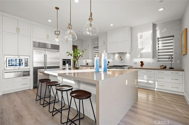 20526 W Overlook Ct, Porter Ranch, CA 91326 - kitchen with a warming drawer, built in appliances, decorative backsplash, recessed lighting, and white cabinetry