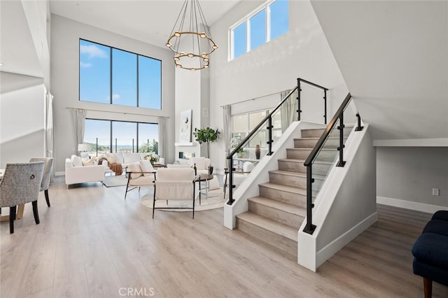 20526 W Overlook Ct, Porter Ranch, CA 91326 - stairway featuring a high ceiling, wood finished floors, a chandelier, and baseboards