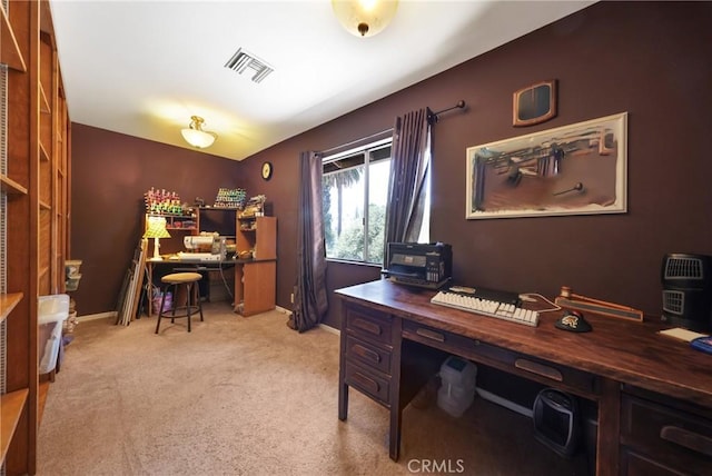office area with visible vents, baseboards, and light carpet