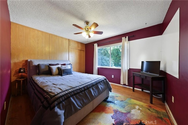 120 Franklin Ave, Redlands, CA 92373 - bedroom featuring wood finished floors, wooden walls, a textured ceiling, a closet, and a ceiling fan