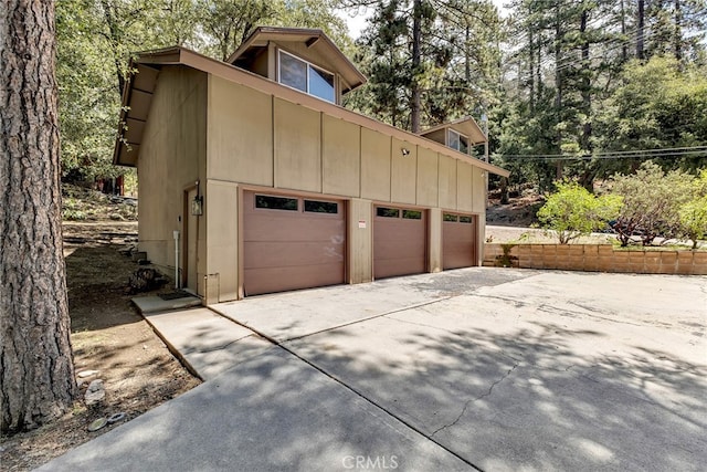 garage featuring concrete driveway