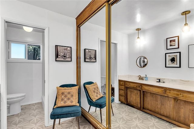 bathroom with toilet, tile patterned floors, baseboards, and vanity